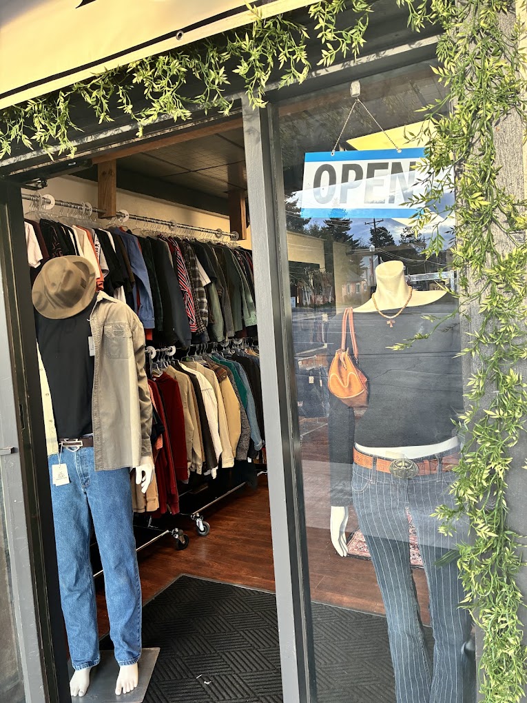 Open door at Timeless Niche with mannequins and hanging greenery